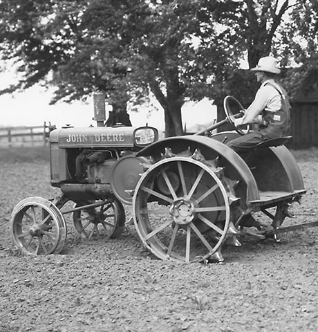John Deere 历史性的“GP”通用拖拉机在田间拖动 John Deere 7 号旋转中耕锄