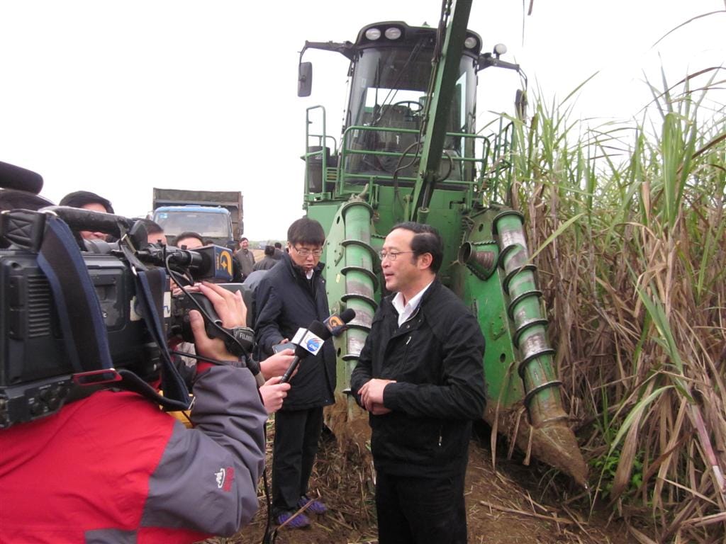 广西自治区副主席陈章良在约翰迪尔新式甘蔗收割机广西展示会上接受媒体采访。